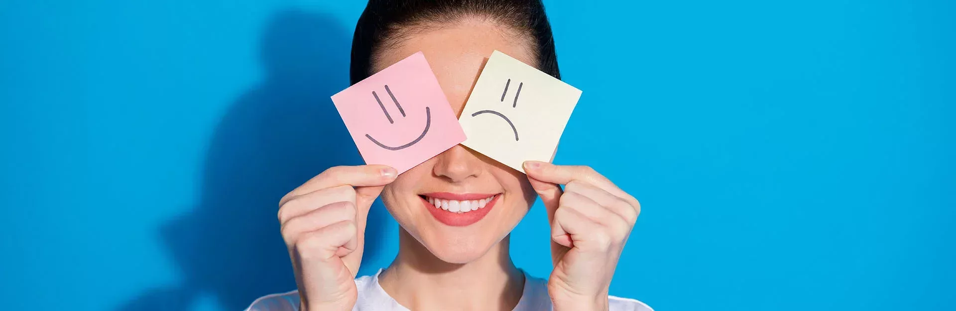 Frau die lächelt mit Post-Its vor den Augen